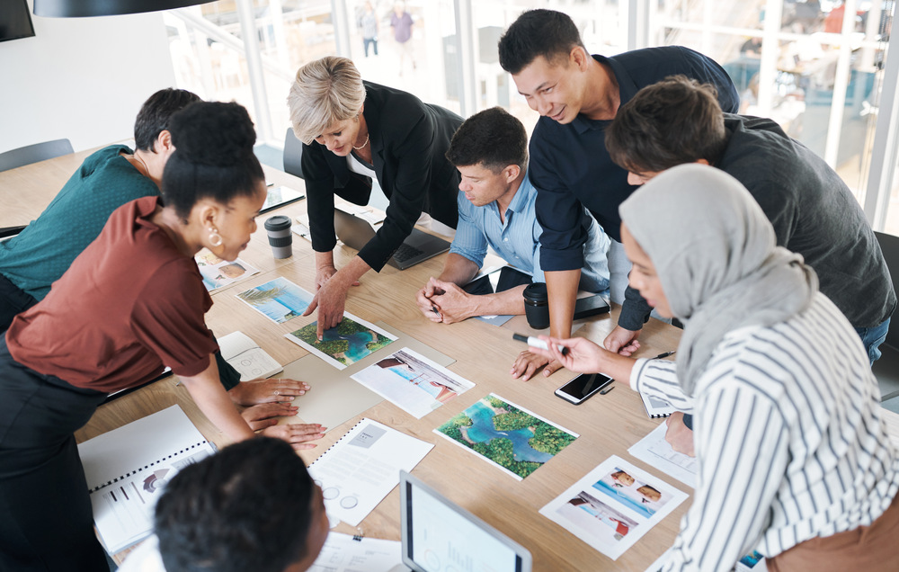Shot Of A Group Of Businesspeople Discussing Paper BQNBKF6